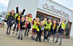 School children jump into the air in front of Gulbenkian