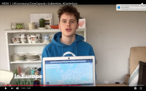 A boy holds up a laptop showing a map of Europe