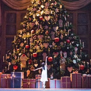 An image of a ballet dancer stood in front of a Christmas tree