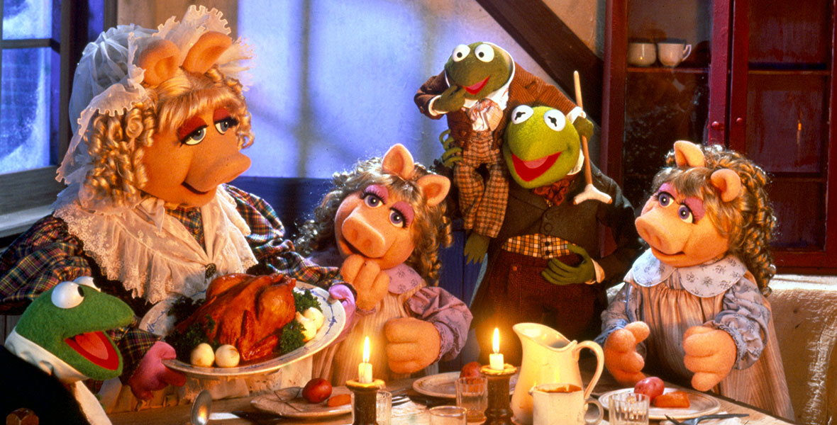 Puppets of various animals gather around a Christmas dinner.