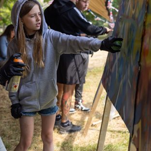 A young girl graffitiing