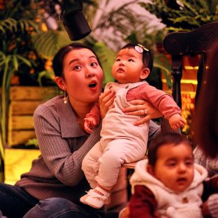 Mother holds baby up looking at something we can't see